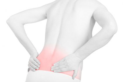 Person touches their lower back in pain.